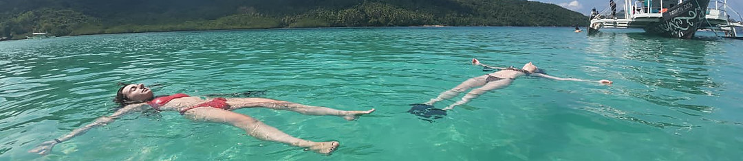 Kraken guests floating in Bacuit Bay near a tour boat